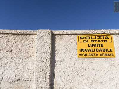 E' protetto da una lungo muro di cinta sul quale � fissato un cartello giallo con su scritto: �Polizia di Stato. Limite invalicabile. Vigilanza armata�